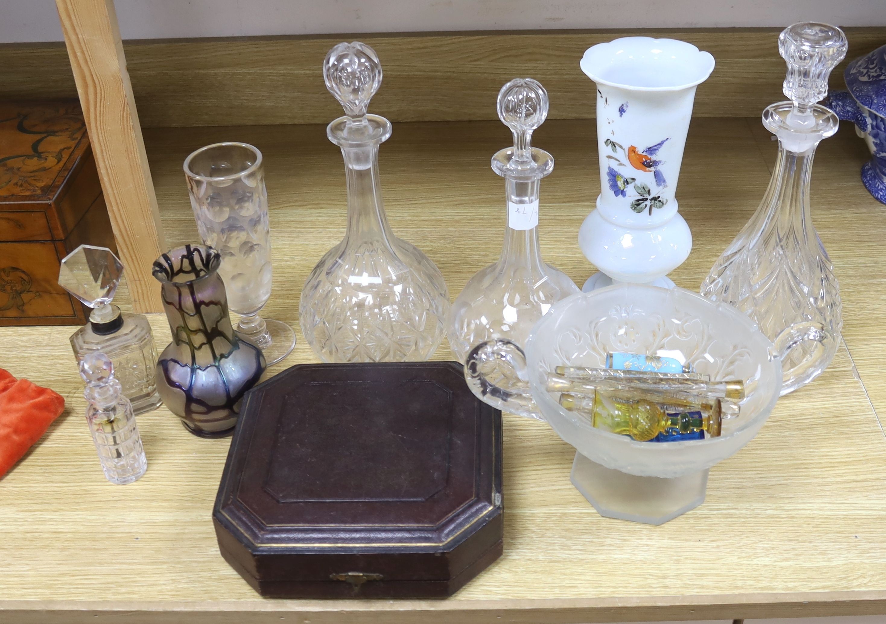 A collection of glass perfume bottles, three decanters, two scent bottles with cut glass stoppers and two handled bowl and an Art Nouveau style vase and plated cruet